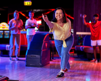 a group of people ten pin bowling. 