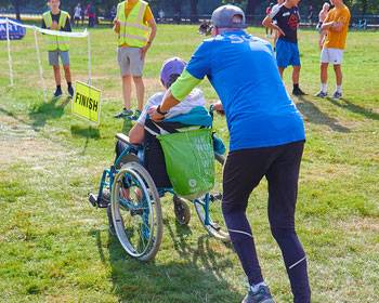 Image of a person running and pushing a wheelchair